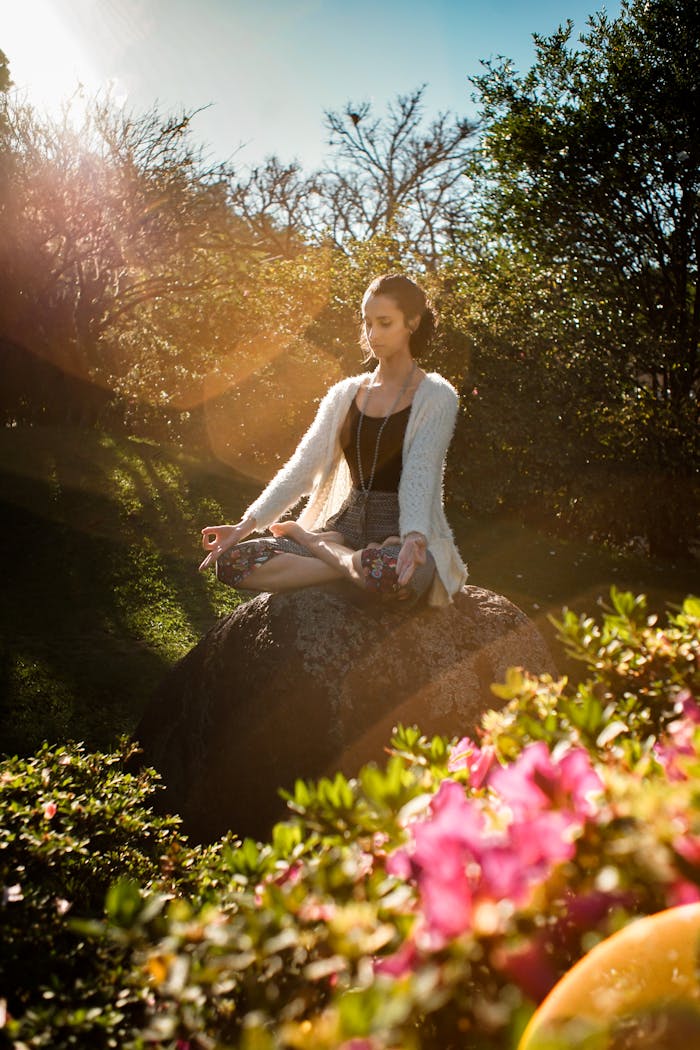 Mastering the First Impression: Your intriguing post title goes here Woman in tranquil meditation pose outdoors, bathed in sunlight, surrounded by lush greenery.